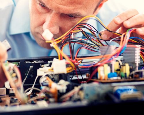 Ectronics engineer repairs an audio-video device. Man repairing electrical component of a computer